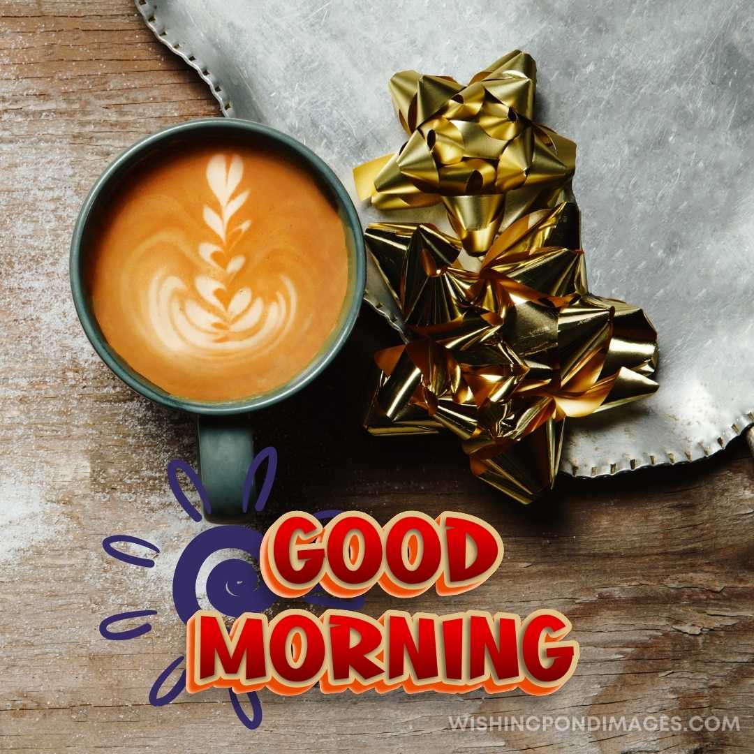 A cup of coffee in green colored cup next to gold colored decoration sitting on the table. Good Morn